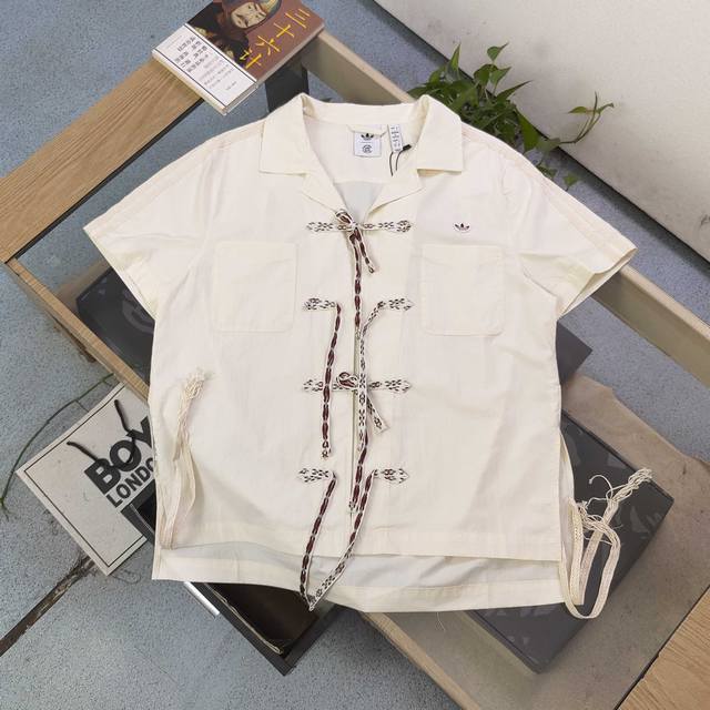 上新 款号 Kl5081 2025新款Adidasclot联名阿迪达斯三叶草蝴蝶扣限定款短袖衬衫 复古与潮流的碰撞 设计巧思 米白色调 简约而不失格调 翻领设计