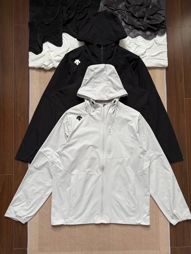 descente 迪桑特 25Ss砖柜在售 夏季户外综训运动梭织外套上衣 面料方面 这款风衣采用高密度防风防泼水面料 轻盈不易皱 手感柔软顺滑 在保持舒适穿着体