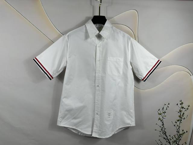 Thom Browne tb短袖衬衫袖口织带 牛津纺100%面料采用高定牛津纺高支纯棉面料 工艺精湛 做工高档 扣子采用透明琉璃扣 衬衣全流水线制作 走线整齐