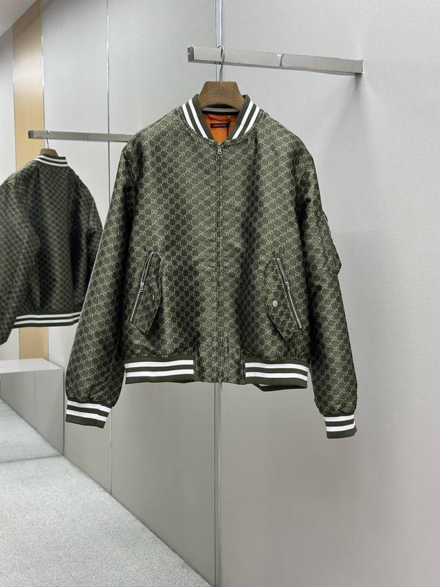 gucc1古驰 双G满印长袖拉链飞行员外套 缀饰条纹滚边 诠释复古运动风尚 这款拉链夹克一面采用帆布匠心打造 另一面则选用尼龙帆布精制而成 互扣式贴饰令整体设计