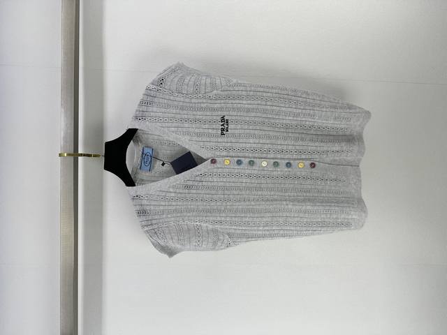 prad*上新 细节 25 夏季新款V领开衫短袖 精致镂空编织 是匠心独运的艺术表达 让衣物在光影间灵动生姿 彩色纽扣似跳跃音符 为简约设计注入活力 打破单调