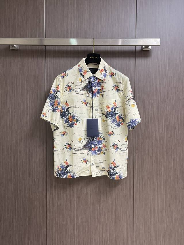 prada Hawaii短袖印花衬衣 这款棉质衬衫呈现Oversize线条 配以别致的保龄球翻领 夏日风格印花在运动设计中融入复古气质 经典胸袋 平直底边 珍珠