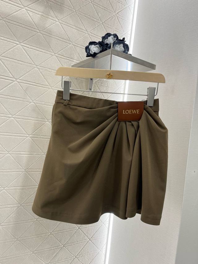 17405# loew*2025新品 皮标褶皱时髦半裙 定制Yb进口西服材质 质感细腻 透气舒适 高街感黑棕两色 单侧捏褶形成斜分走向 以品牌皮标点缀腰间 设计