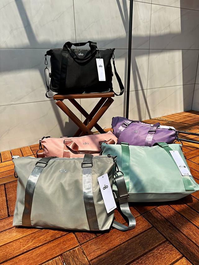 供 Alo运动健身旅行包 轻软尼龙材质面料，高密度耐磨防泼水。质地轻盈柔软好打理，只需要湿毛巾轻轻擦拭就可以啦。大容量主袋，另设有拉链袋，内贴袋，方便物品管理，