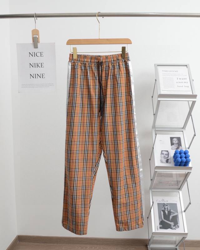 Burberry巴宝莉经典侧边织带格子长裤 采用经典格纹面料 面料带有轻微弹力 半高腰松紧抽绳设计休闲感十足 定位裁剪 男女同款 推荐指数： 颜色:白边 黑边