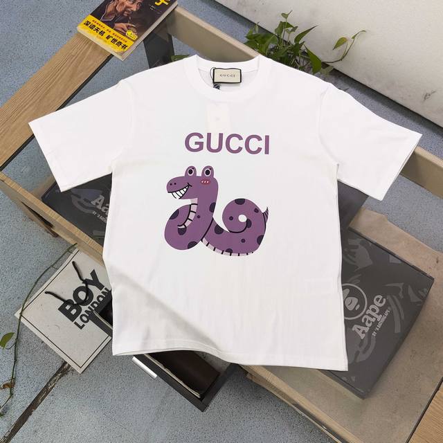 上新 款号：Dg25659 2025新款Gucci古驰紫色蛇年限定图案Logo字母印花休闲情侣短袖T恤，经典图案设计，朋克不羁！！采用250G克重纯棉面料，印花