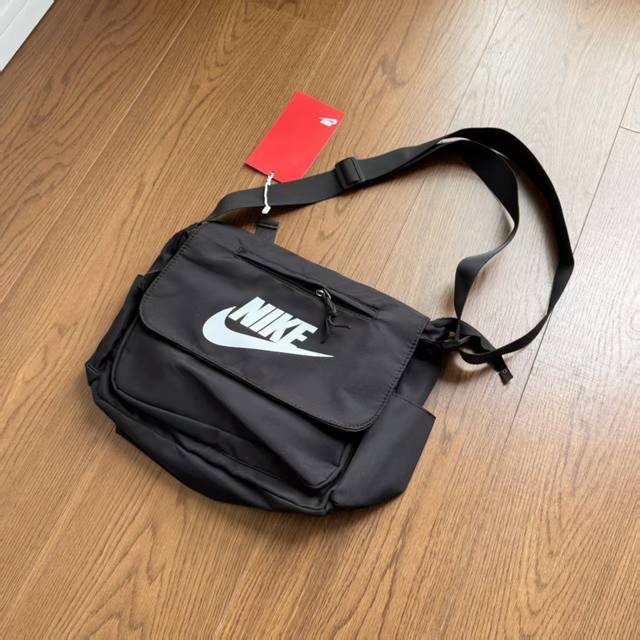 耐克Nike斜挎包情侣款单肩休闲运动百搭时尚简约邮差包拎包。包身采用结实耐用的帆布材质，正面大号Nike Logo,挎带可调节伸缩长短，内里空间超大！颜色：黑色