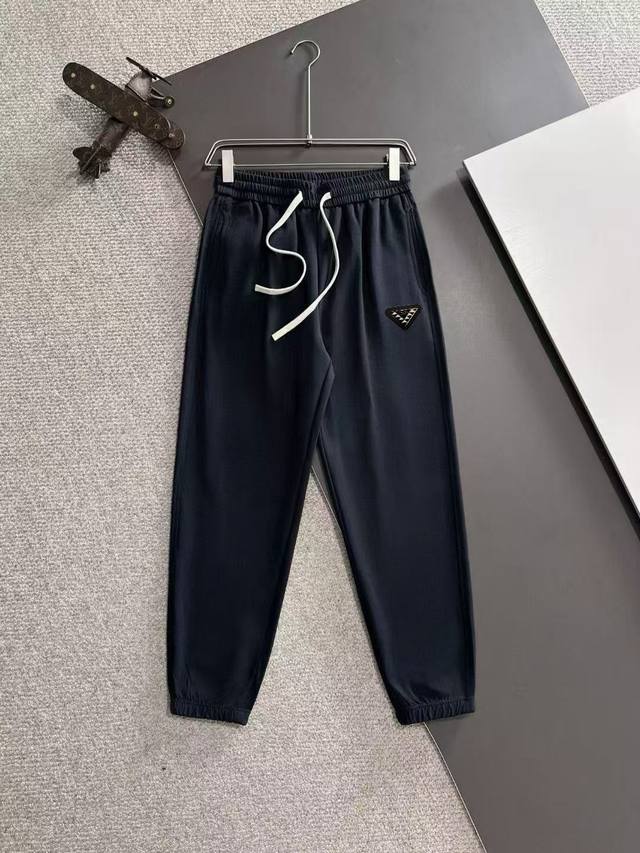 普拉达 顶级货品2025春夏新款休闲裤！品牌经典Logo休闲裤 ，新款式裤型，定制薄款面料，舒适度极好，手触感强烈。辨识度极高，完美品相工艺。 三个颜色：巴黎灰