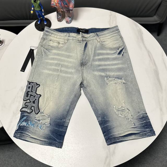 Amiri经典刺绣贴皮破洞字母牛仔修身短裤 水洗大厂出品 满满的高级感 膝盖部分破坏设计搭配拼皮设计 已经作为门面设计 皮质腰部铭牌 此款的重点不在于水洗，而是