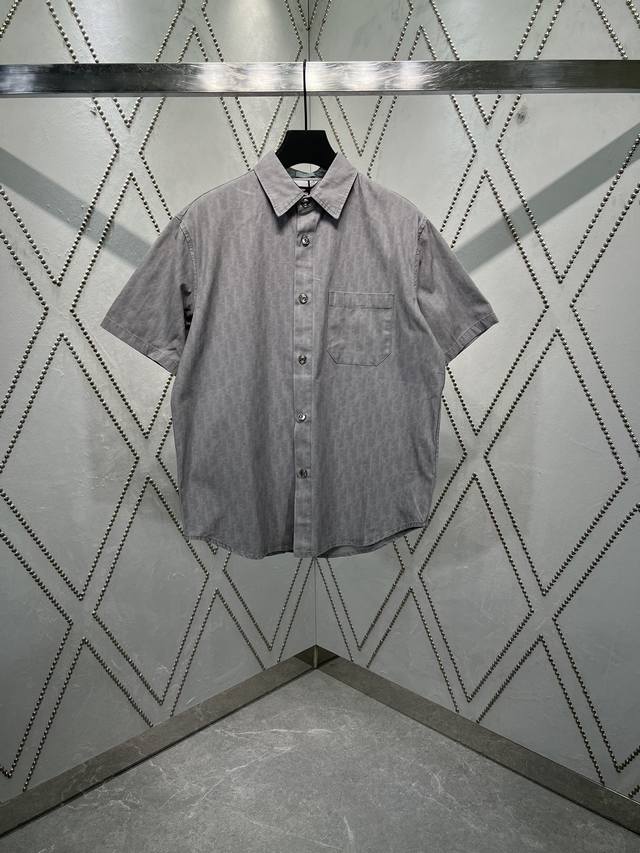 迪奥 25Ss新款外套衬衫通体饰以 Oblique 印花，全新演绎 Dior 的经典图案。采用灰色棉质牛仔布精心制作，胸前带有贴袋，纽扣饰以 Dior 标志。别