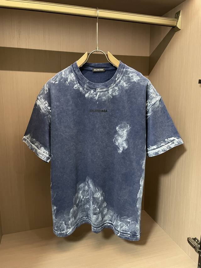 巴黎世家 2025春夏 以独特的做旧调呈现，随性的斑驳纹理，仿佛承载着岁月的故事。简约圆领搭配宽松版型，自在又时髦。胸前标志性的品牌字母，低调间彰显奢华格调与先