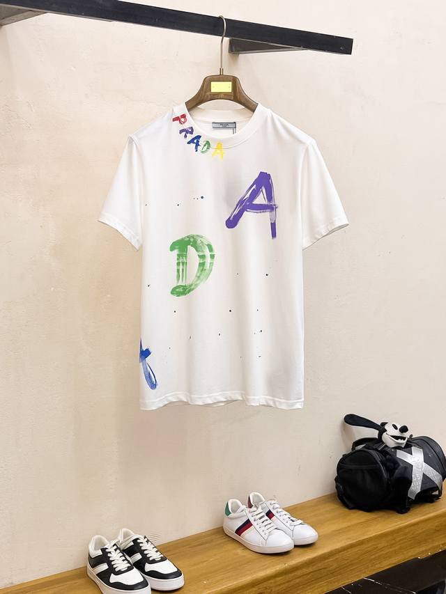 普拉达 高定面料 夏季新品上市时尚经典圆领短袖时尚单品设计，更加时尚舒适，高标准定制，上身非常有型，人工手绘图案 客供辅料，客供进口高档面料质感非常细腻，细节工