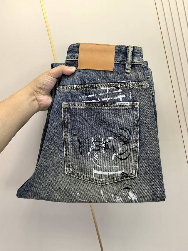 巴黎世家，2025四季款主推刺绣男士牛仔裤。宽腿裤打造，重工涂鸦牛仔面料，定制面料和一般牛仔布料比起来，更加柔软舒适！超重工洗水工艺 双工艺洗水 整条裤子，手感