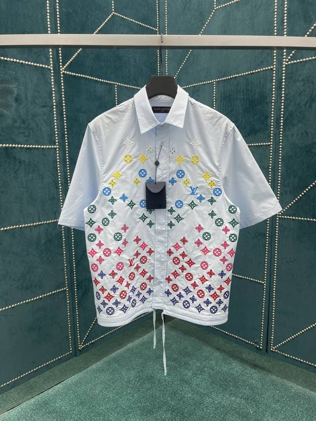 Lv 2025Ss新款短袖衬衫，这款刺绣＋镂空的短袖衬衫，采用抽绳腰带和装饰性刺绣重新演绎。光滑的黑色衬衣饰有同色系英式刺绣 Monogram 花朵，呈现出优雅