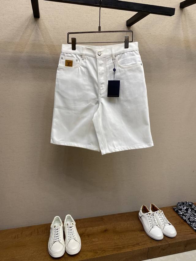 Lv 新款牛仔短裤为水洗棉布融入明线和珠光铆钉，再以 1V 刺绣和 1V 正绒面革贴饰分别点亮后袋与票袋。腰部的 Damier 标签完善考究格调。 尺码：30