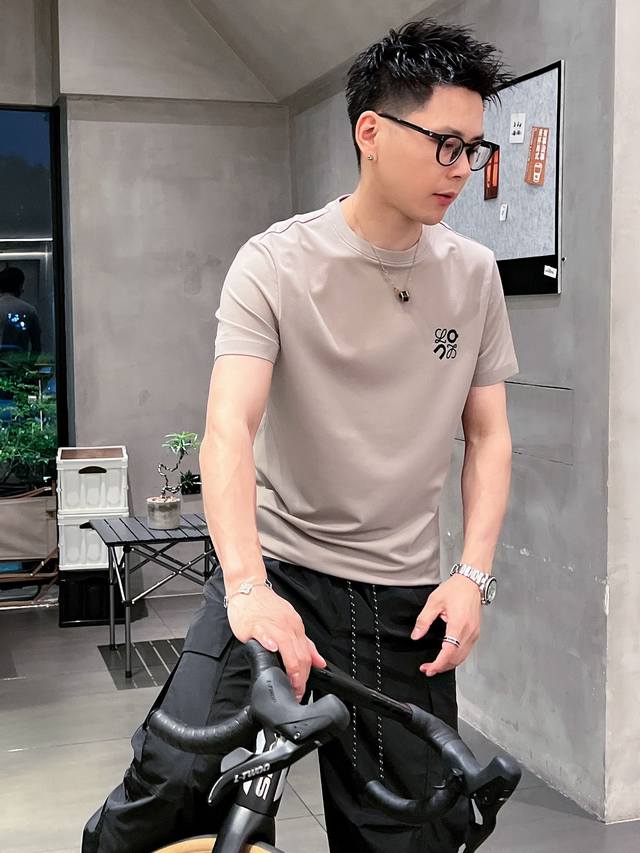 Loe 2025Ss春夏新款圆领短袖T恤，非常适合这个充满活力的季节。这款T恤采用高级定制面料，触感柔软舒适，透气性好，适合春夏季节穿着。经典新元素Logo设计