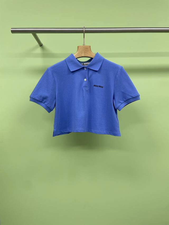 Miumiu2025春夏新派学院精致复古活力Polo，将甜酷氛围精巧版型与华丽钉钻工艺融为一体，延续标志性的甜酷基因，这件上衣以蓝色基底翻领，既藏着少女的温柔底