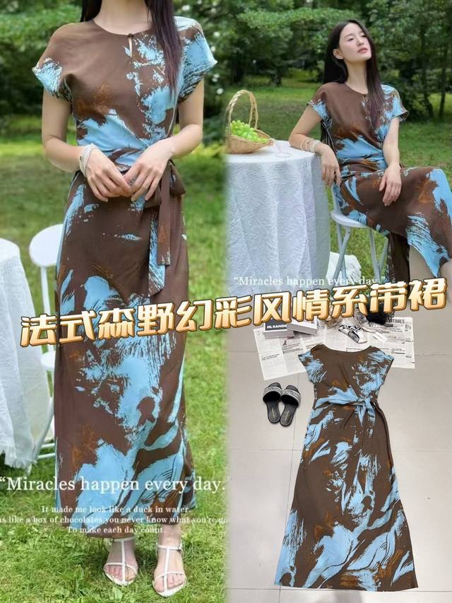 法式[森野幻彩]系带长裙，自然与时尚共谱的诗章。褐蓝交织的泼墨印花，似森林晨雾与湖光交融，于简约圆领、短袖间晕染独特韵味。腰间系带灵动勾勒身姿，于不经意间流露优