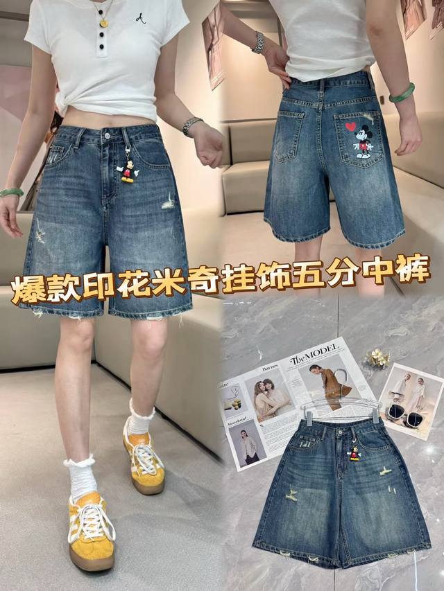 谁能拒绝这条爆款五分牛仔中裤！水洗牛仔蓝，复古韵味拉满。破洞元素个性不羁，米奇印花与挂饰童趣俏皮，时髦又吸睛。恰到好处的五分长度，修饰腿部线条，显腿直腿长。搭配