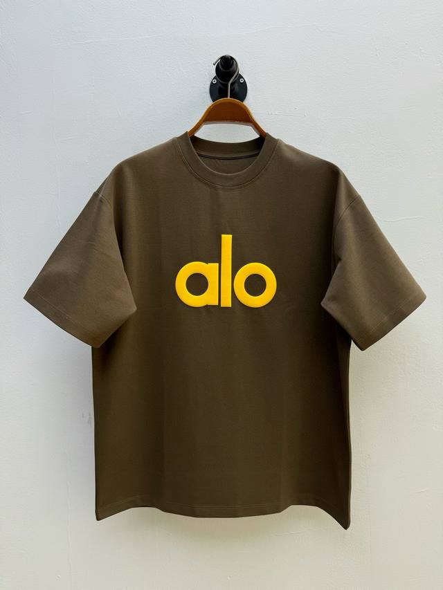 Alo 徽标装饰圆领T恤、代工厂P出品 春夏新品 单品以品牌标志性极简美学为核心，通过胸前对比色品牌徽标与背后贴饰的组合构建独特视角层次感 正面的对比色徽标采用