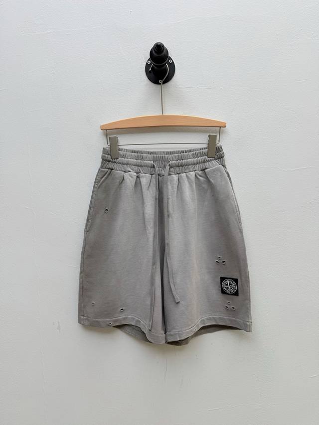 Stone 水洗做旧徽标贴饰短裤、代工厂P品 春夏新品 单品通过复古水洗工艺，将时间痕迹浪漫化表达 褪色肌理与残缺的徽标印花形成呼应 左腿经典方形徽标与破洞设计