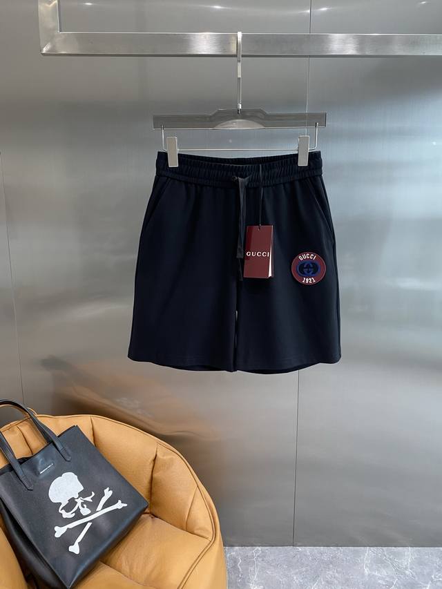 古家 Gucci黑短裤，夏日复古潮流之选 经典黑色百搭又显瘦，抽绳设计方便又时尚。裤身精致的品牌圆形标识，融合复古与潮流元素，彰显独特品味。面料柔软舒适，透气性