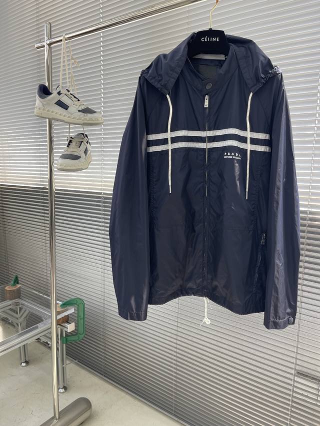 Prad 25Ss新款再生尼龙夹克灵感源自科技服饰，呈现轻盈且实用的剪裁设计。撞色图案细节点亮运动服饰风尚。 码数：S.M.L.Xl 衣长