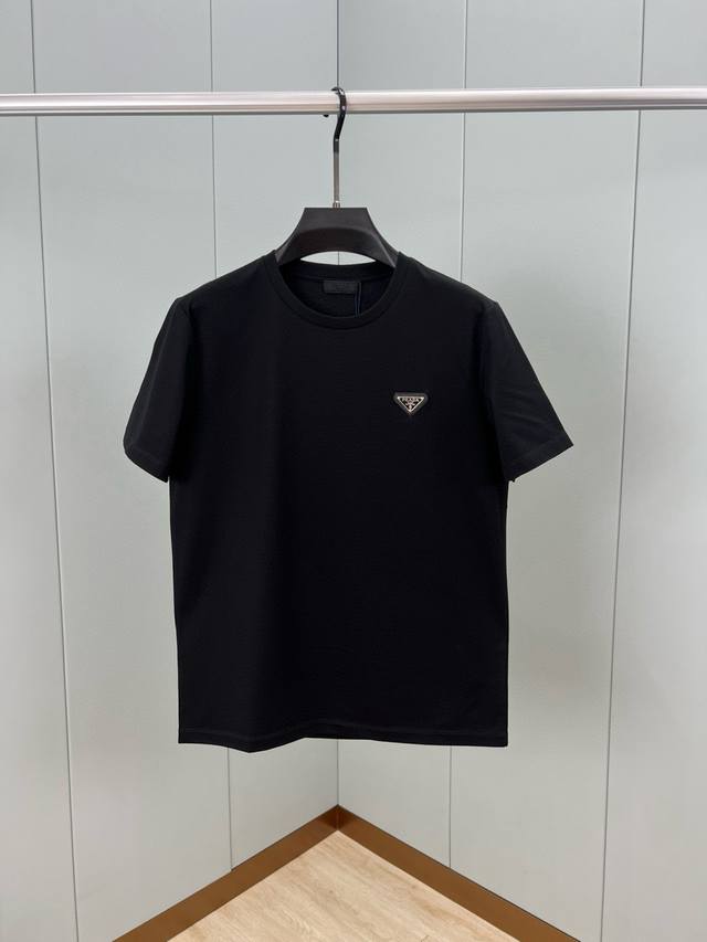 Prada.普拉达 25春夏经典涂珐琅三角形金属徽标短袖T恤，正面胸前缀饰涂珐琅三角形金属徽标为时尚设计增添经典元素，呈现衣橱必备单品。定制80支双股丝光棉面料