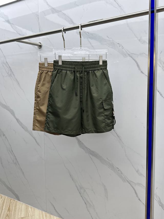 Prada*普拉达 2025Ss夏季经典珐琅三角多功能大口袋侧插袋轻薄速干尼龙抽绳男士短裤外搭 该裤装取材于进口100%梭织尼龙，材质透气吸湿排汗，久穿也不易起