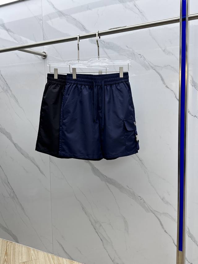 Prada*普拉达 2025Ss夏季经典珐琅三角多功能大口袋侧插袋轻薄速干尼龙抽绳男士短裤外搭 该裤装取材于进口100%梭织尼龙，材质透气吸湿排汗，久穿也不易起