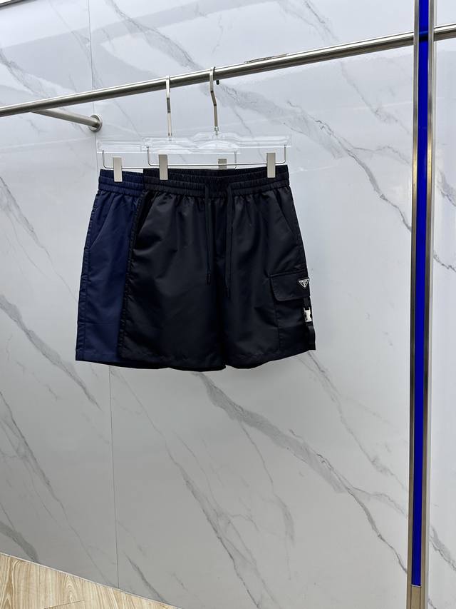 Prada*普拉达 2025Ss夏季经典珐琅三角多功能大口袋侧插袋轻薄速干尼龙抽绳男士短裤外搭 该裤装取材于进口100%梭织尼龙，材质透气吸湿排汗，久穿也不易起