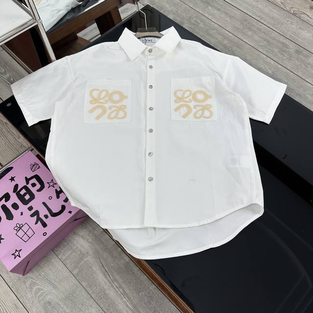Loewe 罗意威联名款新款胸前字母刺绣大Logo翻领短袖衬衫男女同款 罗意威以西班牙的热情浪漫为灵感，秉持精湛工艺与创新精神，不断演绎着时尚经典。 这款罗意威