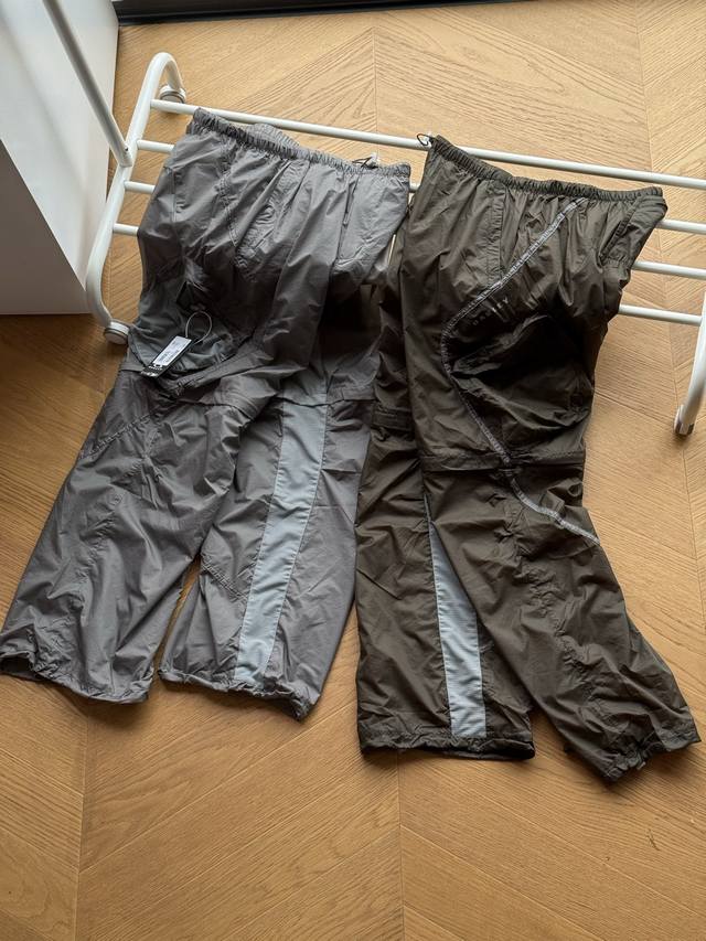 供 Oakley欧克利 日本主线 徽标撞色可拆卸工装尼龙机能裤 橄榄绿 灰色 31 32 33 34 多功能性是这款防风尼龙裤的最大特点，通过膝部的拉链可以根据