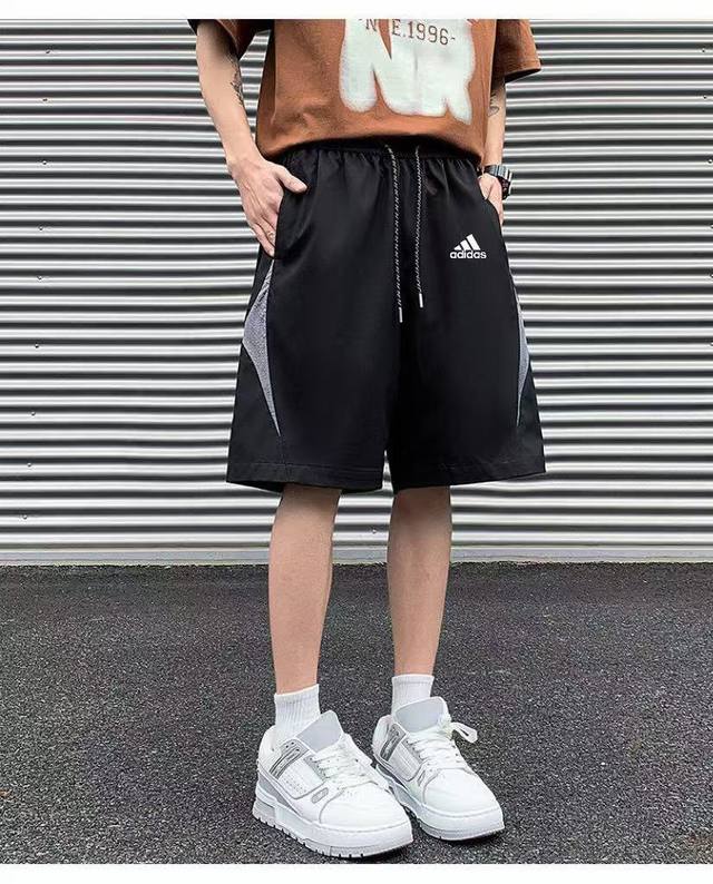 供 2025新款Adidas阿迪达斯三叶草Logo印花休闲情侣速干短裤五分裤 宽松沙滩短裤经典中迸发潮流气息。蓝黑三叶草标志醒目亮眼，品牌字母“Adidas”个