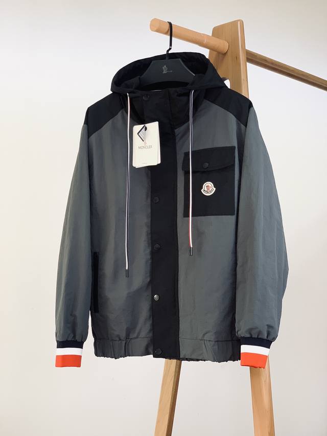 Prada 普拉达 2025Ss早春新品 连帽夹克外套，该款夹克外层超柔聚酯纤维防风防水，功能与时尚型兼具。100%聚酯纤维成分的织物布面光洁细腻而且防水，呈现