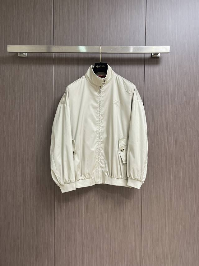 Miumiu字母贴布刺绣外套，采用浅咖色棉布针织面料，内里红白格纹里布，罗纹领细节，隐藏式金属拉链开合门襟，针织下摆和衣袖，整体走线平直细腻，面料舒适柔软，颜色
