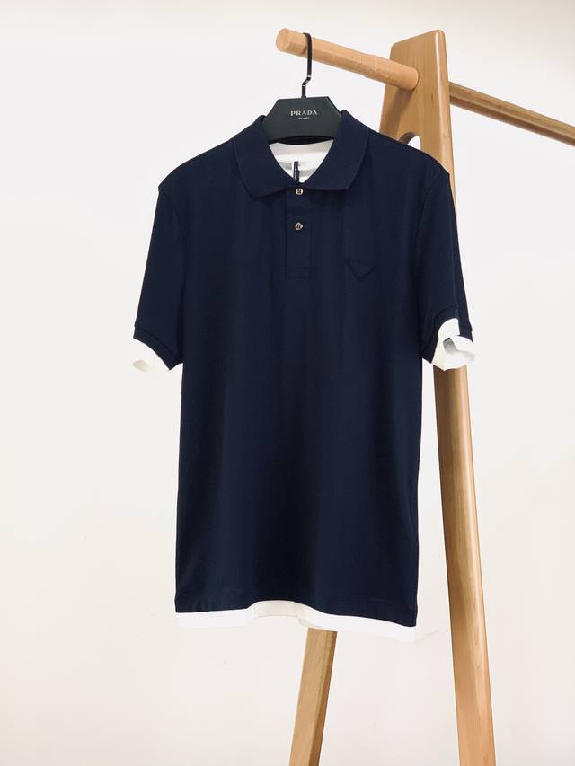 Prada 普拉达 2025Ss春夏新品 全新假两件Polo系列，将意大利匠心融入每一处设计，用细节诠释高端质感，让经典单品焕发新魅力： 胸前立体三角徽标，品牌