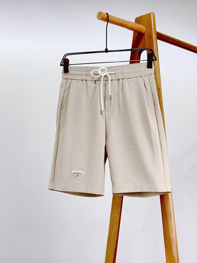 Prada 普拉达 2025Ss春夏新品 经典三角标抽绳休闲短裤 时尚系列，独特拼料设计，抽绳休闲裤。 订纱开始订染和订纺。 国内某大厂出口日本 和供应几大顶级