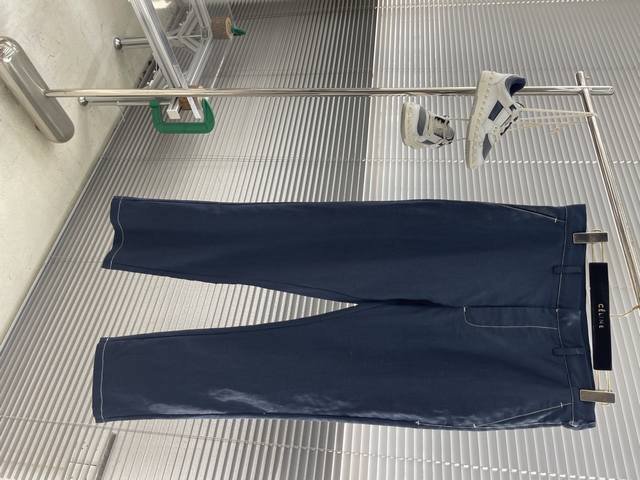 Prad 25Ss新款海军蓝亚麻休闲长裤 这款长裤采用亚麻面料制作而成，手感非常舒适柔软，隐藏式钩扣与拉链门襟，正面斜口插袋，背面纽扣嵌线袋，背面饰以织物三角形