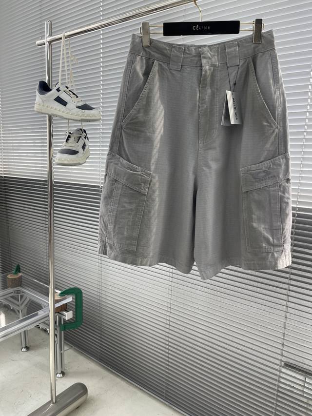 Balenciag 25Ss Loop 水泥灰做旧工装短裤 工装裤以高阶定制工艺重构功能性设计。主体采用高支高密格纹梭织面料，经多道洗水处理呈现做旧纹理，叠加喷