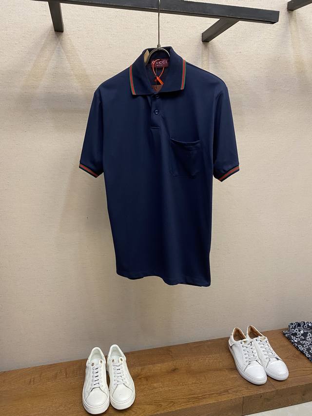Gucci，Gucci 标识Polo衫 定制三角珠层雅致珠地棉 质感十足 舒适贴肤 深蓝雅韵 静谧而优雅 正面饰有Gucci标识字样展于胸前 如同贵族徽章 彩边
