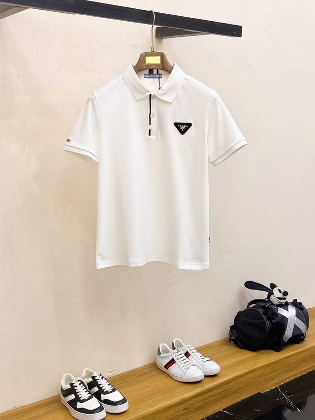 普拉达 2025春夏新款男士标识短袖Polo衫，延续经典商务休闲翻领Polo恤.该款Polo衫采用丝光双面棉质珠地面料制成，隽永设计可跨越时尚潮流。经典款型，2