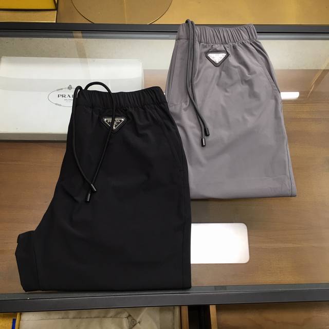 专柜新品 Prada 普拉达 2025Ss春夏新品 时尚男士休闲裤，甄选冰丝弹力面料打造，质感柔软丰富，整齐干净利落，客供五金辅料装饰，辨识度极高，整身立体漂亮
