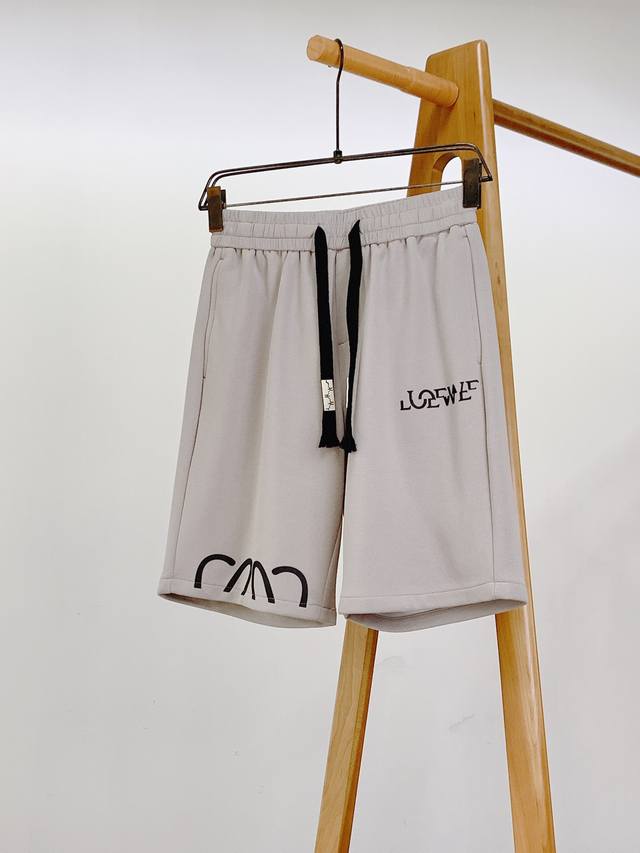 Loewe 罗意威 2025Ss春夏新品 撞色抽绳短裤纯黑底色经典百搭，仿佛时尚画布，承载品牌独特印记。 标志性“Loew*”字母以浮雕配色呈现，立体醒目。前侧