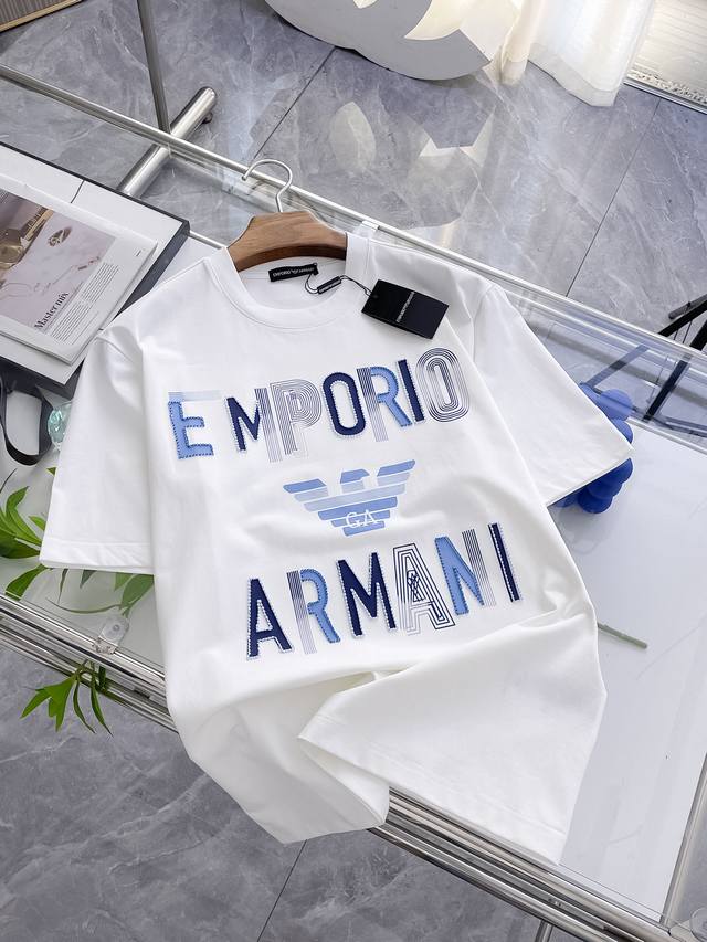 阿玛尼 Emporio Armani 短袖T恤，简约而不失格调。经典品牌名以蓝白渐变呈现，标志性鹰标居中，彰显品牌的优雅与大气。它将时尚与舒适完美融合，穿上它，