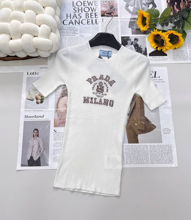 Prada 胸口经典Logo嵌花短袖针织衫 这款修身版型针织长袖源自经典罗纹针织系列 简洁修身版型与别致撞色字母Logo搭配 超级时髦百搭 实用主义 简洁廓形与