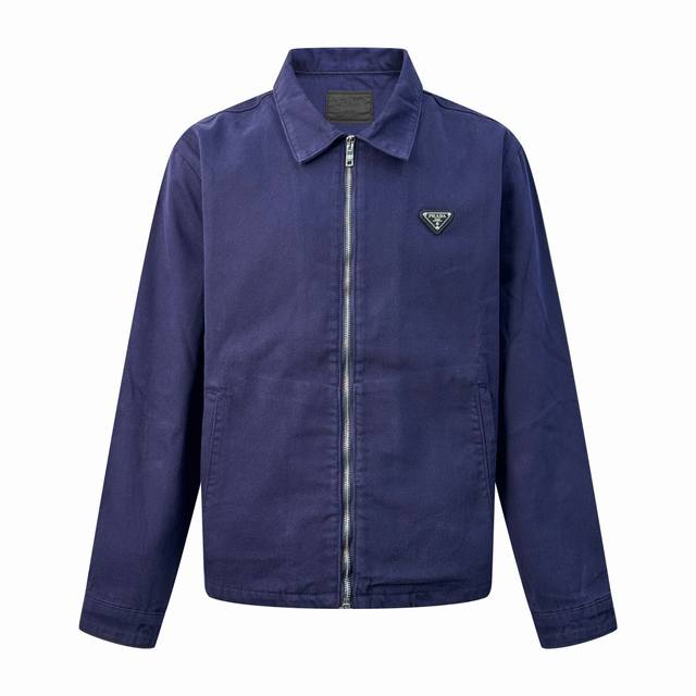 Prada 三角标做旧牛仔夹克 定制纳米品蓝精纺牛仔布 质感上乘 柔软坚韧 舒适贴肤 以品蓝色为底色 高贵而优雅 标志性三角形徽标镶嵌在夹克之上 低调却极具辨识