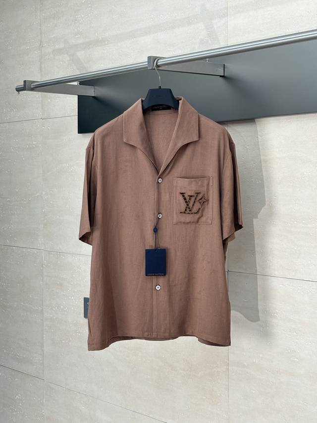 Lv 路易 春夏新款棉麻镂空刺绣短袖衬衫 本款村衫选用桑蚕丝和大麻混纺，呈现山东绸一般的细腻肌理。英式刺绣工艺于胸前口袋勾勒镂空标识，开领短袖剪裁传递夏日惬意。