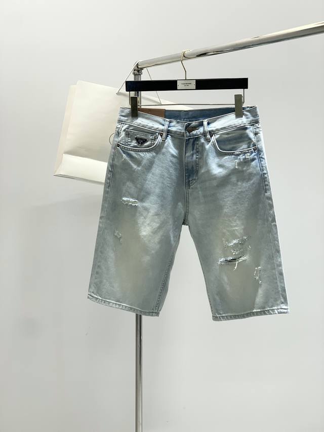 Prada 普拉达，2025夏季最新品，专柜同步有售，原单狠货，水洗休闲牛仔短裤，进口原版水洗弹力面料，舒适有弹性，顶级印花工艺字母图案装饰Logo，原版五金辅