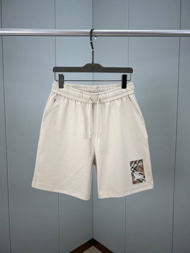 Burberry.巴宝莉 夏季男士新品格纹标签贴花冰氧棉休闲短裤，正面左侧脚口边贴花巧妙融合Burberry格纹马术骑士徽标元素，创意重释品牌标志性设计，弹性松